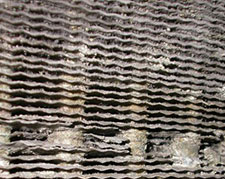 A close view of corroded cooling fins on an indoor evaporator coil